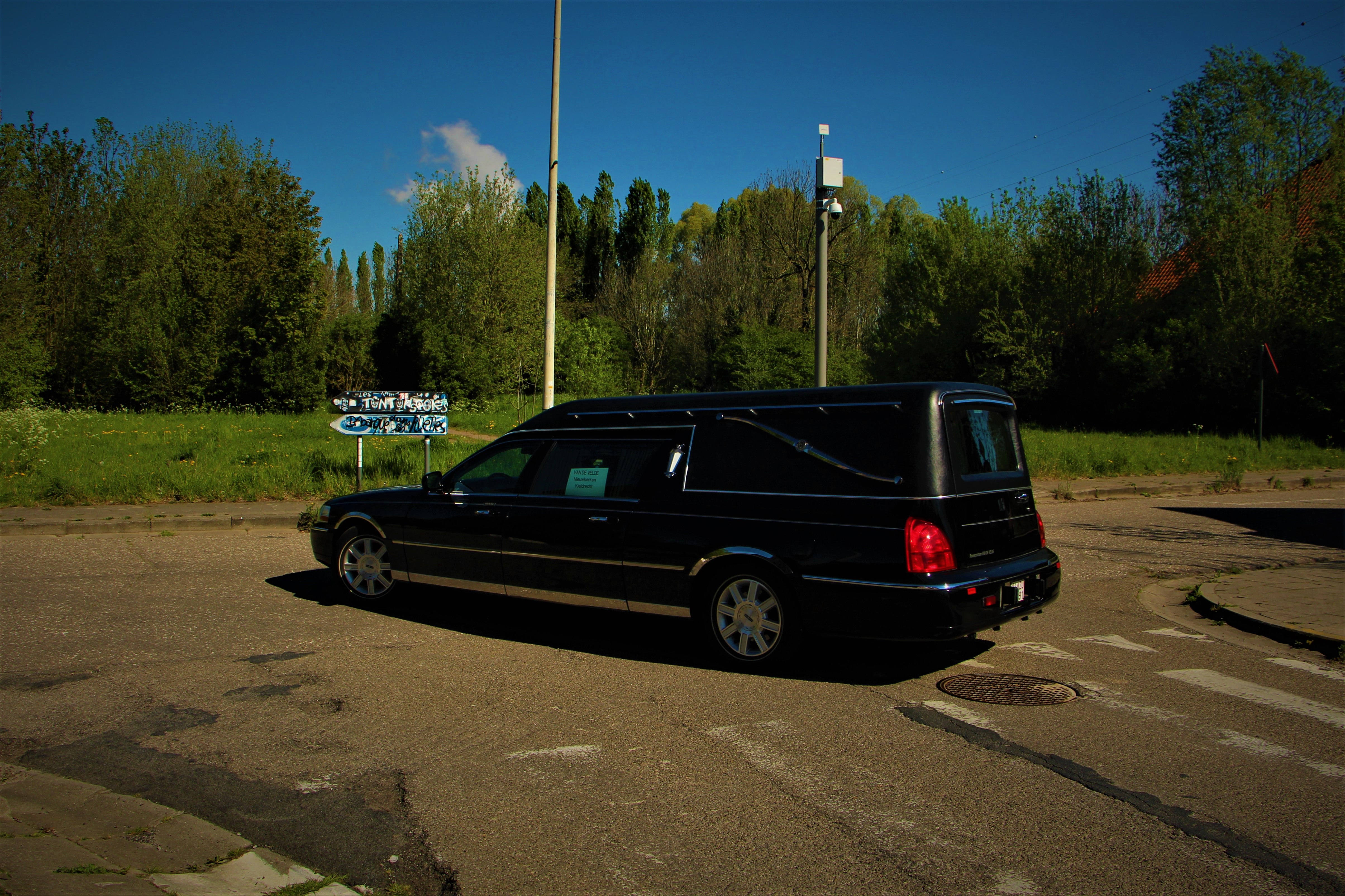 A hearse drives through Doel
